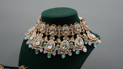 Aurora - A sophisticated Tyaani Kundan set featuring stunning pearl accents and dangling green and pink beads for a captivating display. Includes Jhumka earrings (2.4 inches)