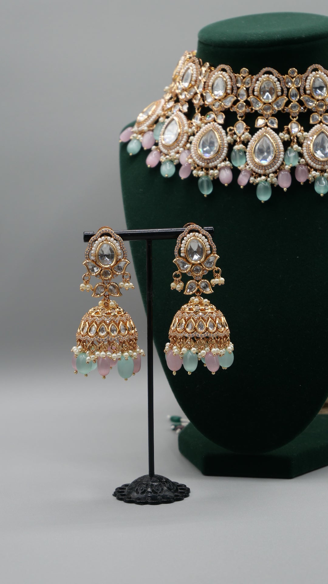 Aurora - A sophisticated Tyaani Kundan set featuring stunning pearl accents and dangling green and pink beads for a captivating display. Includes Jhumka earrings (2.4 inches)