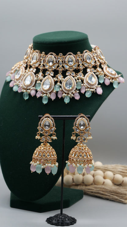 Aurora - A sophisticated Tyaani Kundan set featuring stunning pearl accents and dangling green and pink beads for a captivating display. Includes Jhumka earrings (2.4 inches)