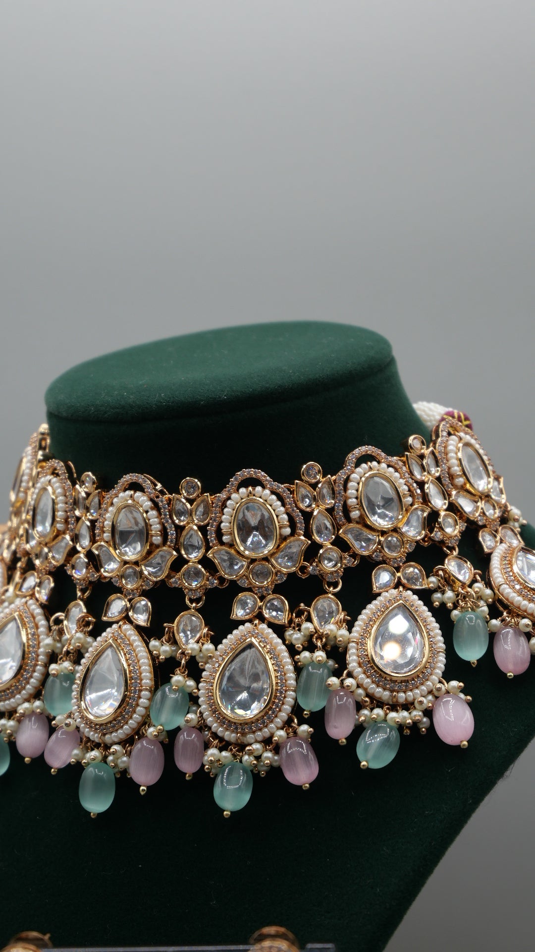 Aurora - A sophisticated Tyaani Kundan set featuring stunning pearl accents and dangling green and pink beads for a captivating display. Includes Jhumka earrings (2.4 inches)